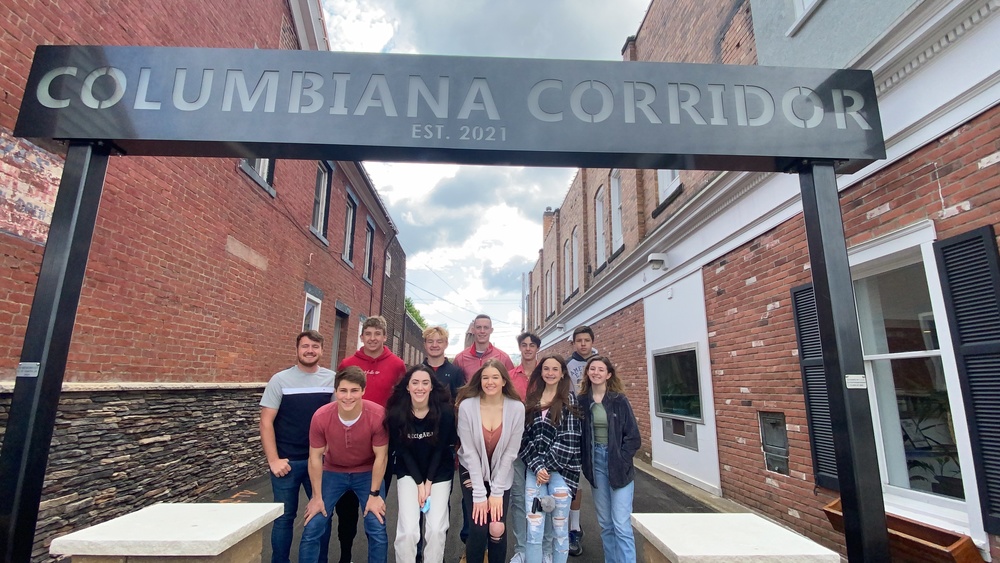 Students in front of Columbiana Corridor Sign
