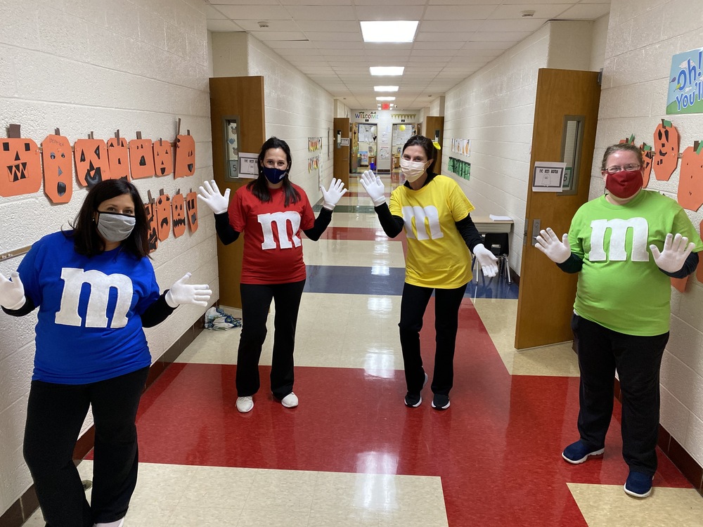 Four teachers dressed as M & M s for Halloween